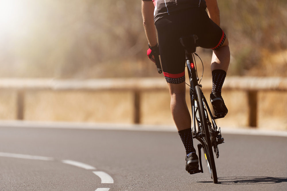 Rear view of a cyclist on a road bike cycling down a highway