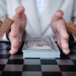 Hands placed on either side of a stack of money