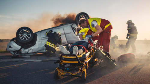 Emergency worker rescuing victim from a car accident